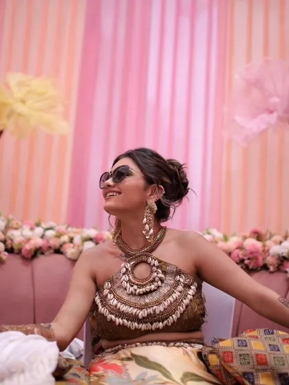 Our client rocking a boho-chic Mehendi look. The long earrings with shell details were the perfect accessory to match her unique, nature-inspired theme and shell-adorned blouse.