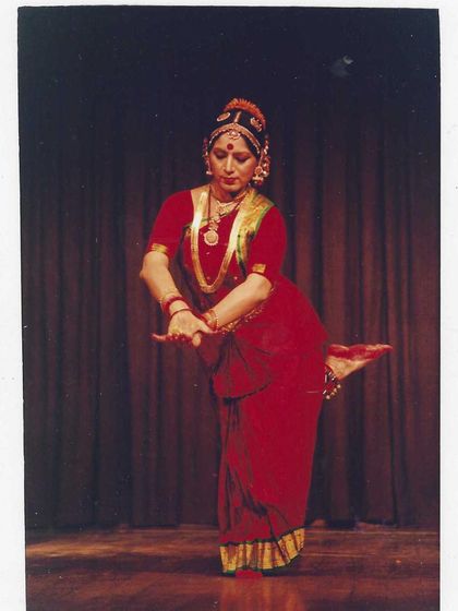 A classic solo performance photograph from my career. Dressed in a traditional red costume, this pose captures the balance and geometric precision that is a hallmark of the Kalakshetra style.