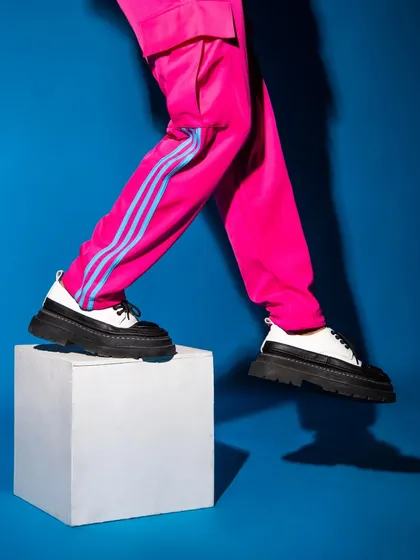 A detail-oriented shot focusing on the footwear and vibrant trousers. This kind of abstract composition is great for grabbing attention in an editorial spread.