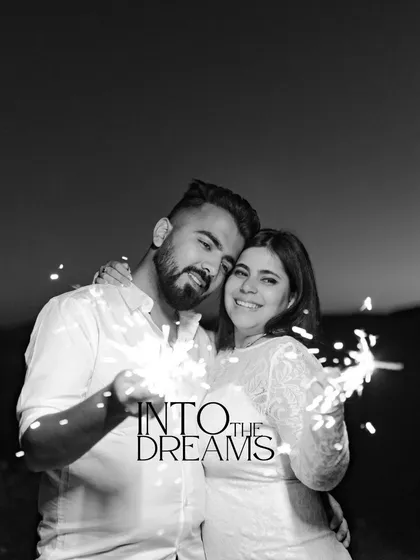 A beautiful black and white portrait with sparklers. This image has a dreamy, magical quality, focusing on the couple's happy faces as they are surrounded by light.
