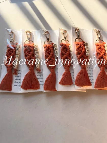 A set of personalized macrame keychains in a warm rust color, each customized with a different name. These make for wonderful and uniform gifts for a group.