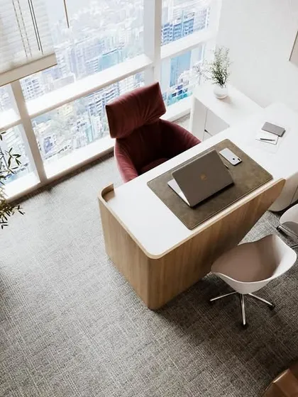 An aerial view of an executive cabin from our Japandi-style office project. The space is designed to be clutter-free and filled with natural light, featuring a modern curved desk, biophilic elements, and clean lines to promote focus and clarity.