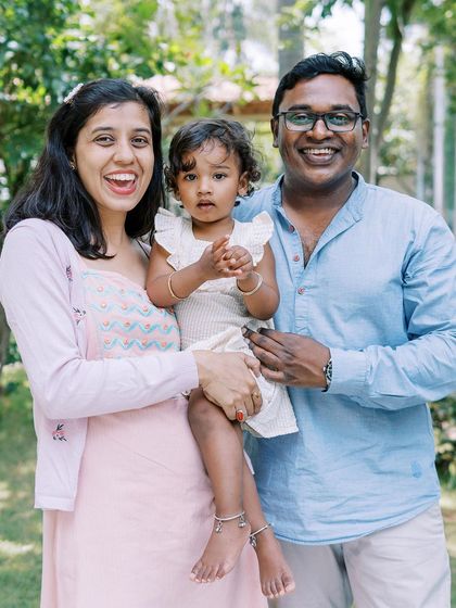 A happy family portrait. The genuine smiles and relaxed poses show a family that is comfortable and enjoying their time together.