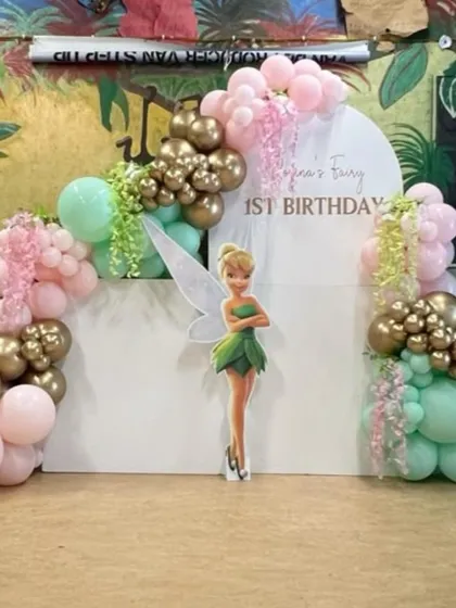 Let us create a fairytale for your child's birthday. This Tinkerbell-themed party features a custom backdrop with a character cutout, framed by a magical balloon arch in pastel pink, mint green, and chrome gold, with delicate floral accents.