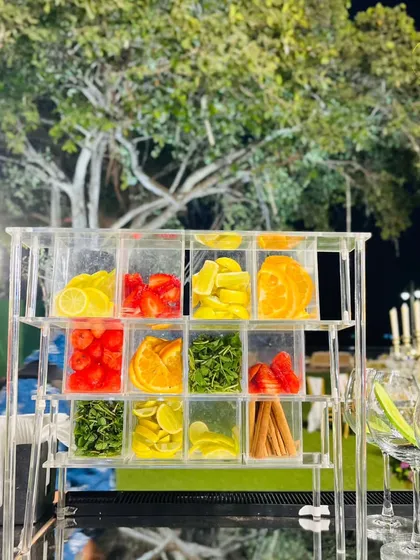 Our garnish station, featuring a clear acrylic organizer filled with fresh-cut strawberries, lemons, oranges, and herbs. Quality ingredients are key to our craft.