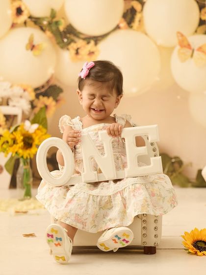 Capturing the pure, unscripted joy of turning one. This little one's expression is priceless against our bright and cheerful sunflower backdrop.