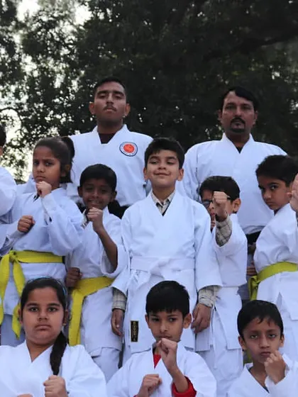 A group of our youngest karate students posing with their instructors. They are the future of our academy, learning focus and respect from day one.