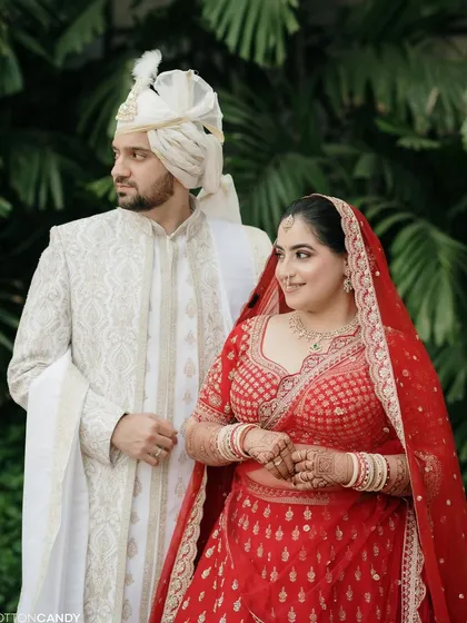 A classic portrait of the bride and groom. Sakshi's timeless red bridal look stands out beautifully, radiating elegance and happiness.