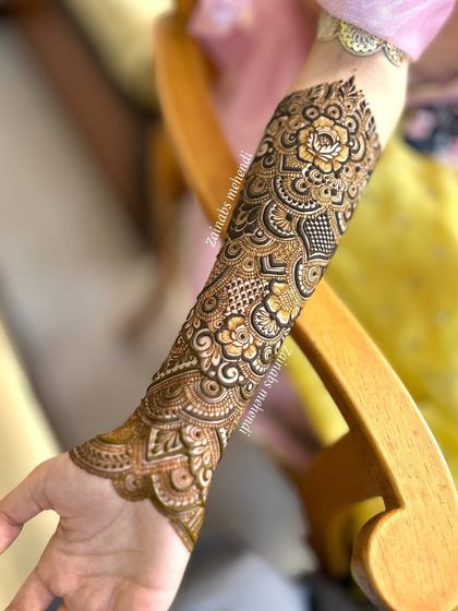 A beautiful shot of Momina's full arm henna, showcasing the intricate details and the flow of the design.