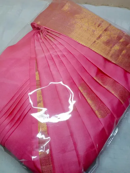 This pink saree is packed and sealed, demonstrating the final product you receive.