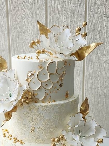 Another detailed shot of the jeweler's anniversary cake, focusing on the top tier's petal-like texture and gold accents.