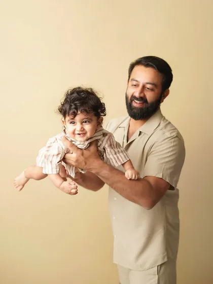 A father playfully lifts his son, both of them smiling. This photo is full of energy and the special bond between a dad and his boy.
