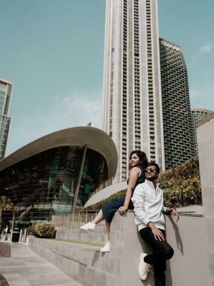 A cool, urban-style portrait of the couple with the Dubai Opera and city skyline as the backdrop.