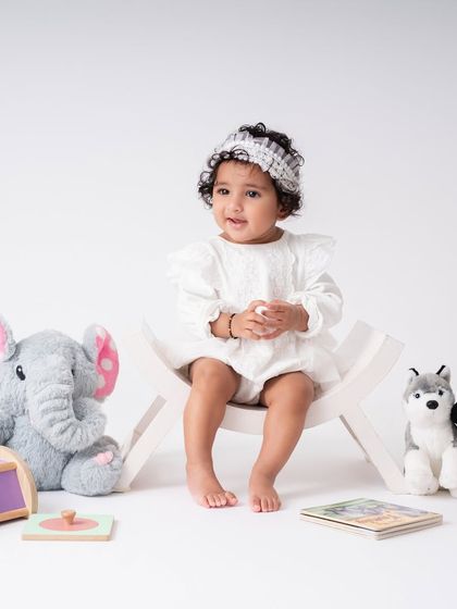A wider shot of the sitter session setup. I use simple, clean backgrounds and a few favorite toys to create a space where the baby is the star of the show.