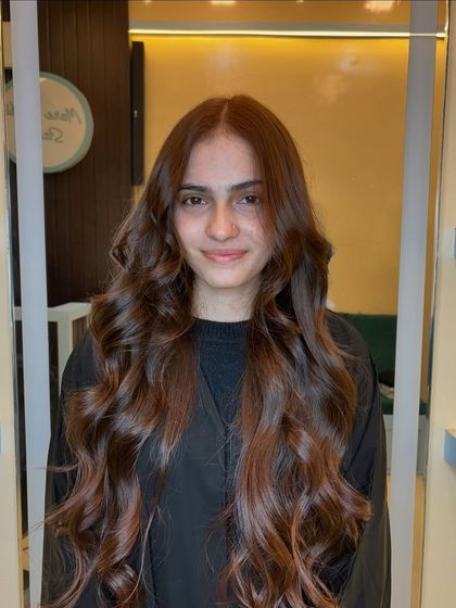 A stunning copper brown global color. This rich, warm shade looks incredibly healthy and vibrant, styled in long, flowing waves.