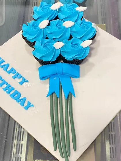 A simple and elegant cupcake bouquet, wishing someone a "Happy Birthday" with beautiful blue rose cupcakes.
