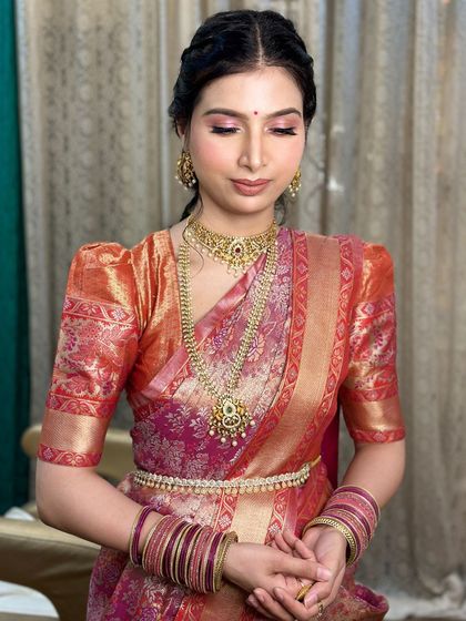 A close-up of the daughter's makeup. The look features soft pink eyeshadow and a traditional braided hairstyle.