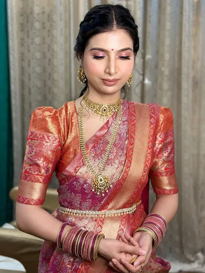 A close-up of the daughter's makeup. The look features soft pink eyeshadow and a traditional braided hairstyle.