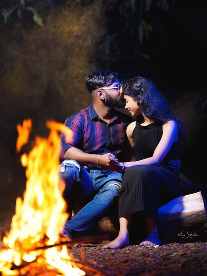 A tender forehead kiss by the campfire. This classic romantic pose is made even more special by the warm, flickering light of the fire.