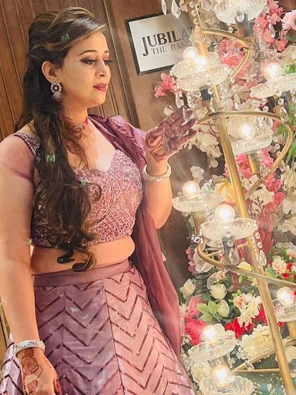 A candid shot of a client enjoying the party in her rental lehenga. The outfit sparkles beautifully even in ambient lighting.