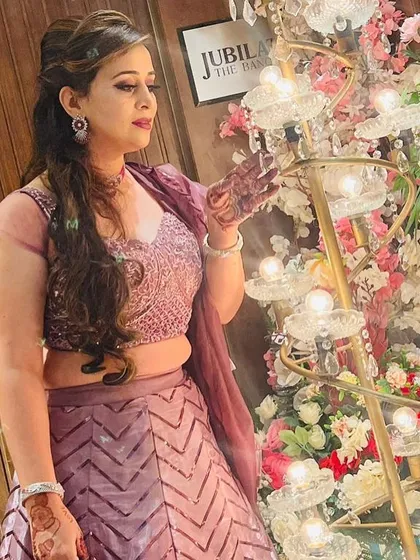 A candid shot of a client enjoying the party in her rental lehenga. The outfit sparkles beautifully even in ambient lighting.