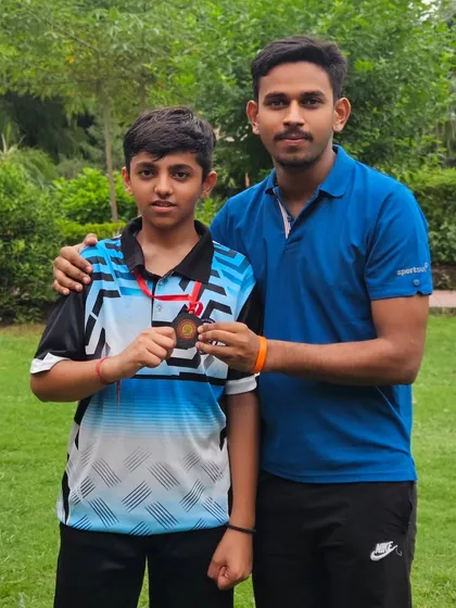 Posing with a student and his medal after a competition. Seeing the pride on their faces is my biggest reward as a coach.