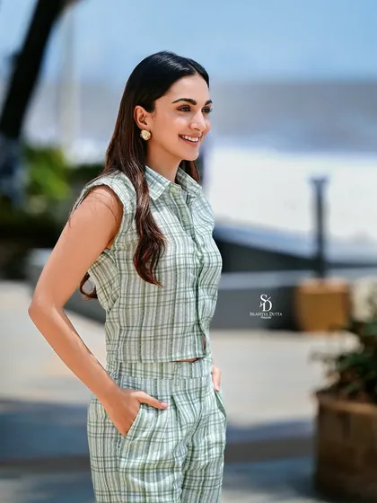 A candid shot of Bollywood actress Kiara Advani for Anandalok. Her bright, natural smile and the casual beachside setting create a fresh, relaxed, and relatable celebrity portrait.