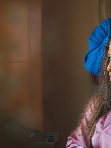 A candid moment of the bride getting her hair styled, lost in thought before the big moment.