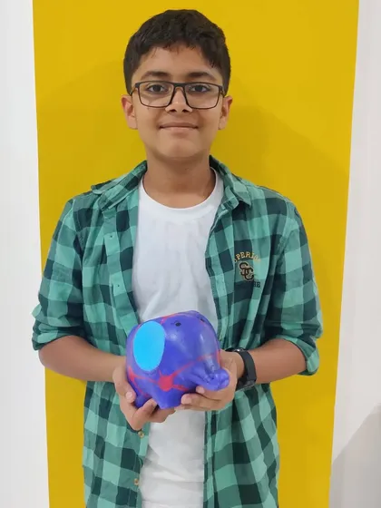 This proud artist is showing off the colorful elephant planter he created during a birthday workshop.