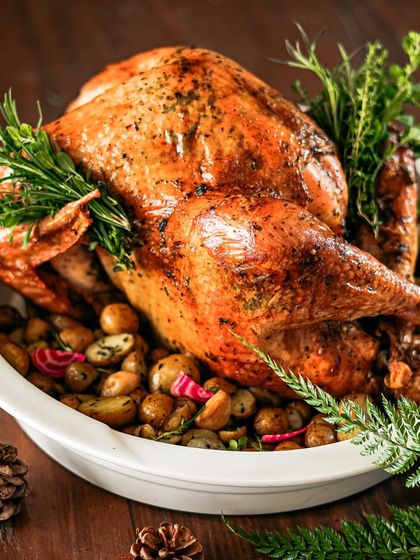 A classic Christmas centerpiece: a whole roasted turkey, glistening and golden-brown. We brine and roast our turkeys to perfection, serving them with all the traditional trimmings for a memorable holiday feast.