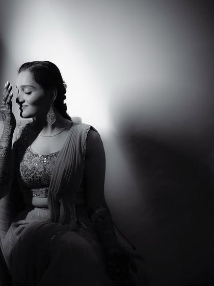 A dramatic black and white portrait of the bride, with light and shadow playing across her face as she smiles.