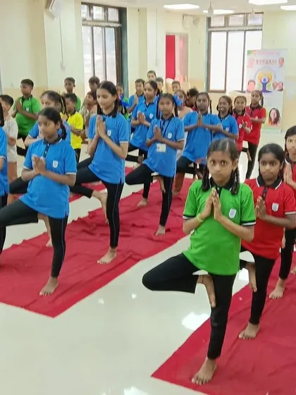 Young students practicing Vrikshasana (Tree Pose) during a school session. This helps them build balance, focus, and confidence from an early age.