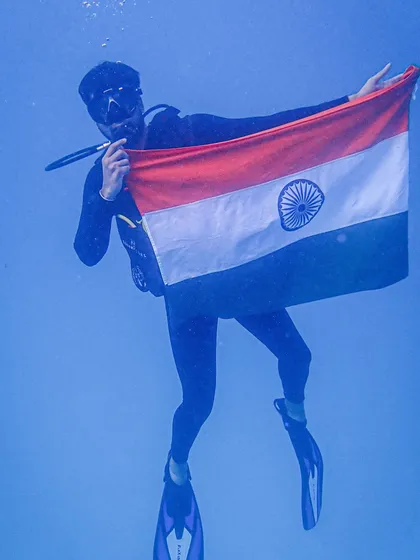 A solo diver holds the flag during our Independence Day dive. It's a moment of quiet reflection and pride, surrounded by the beauty of the ocean.