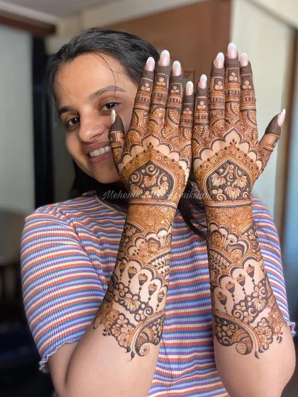 A bright smile from a happy client, thrilled with her intricate and beautiful mehendi design.