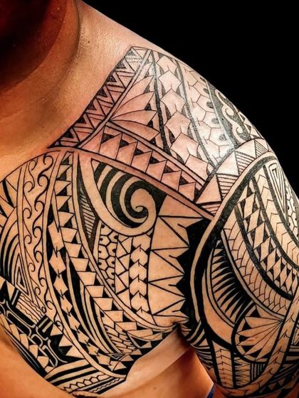 A completed Polynesian shoulder and chest tattoo with dark, solid shading. This style is known for its bold look and cultural significance.