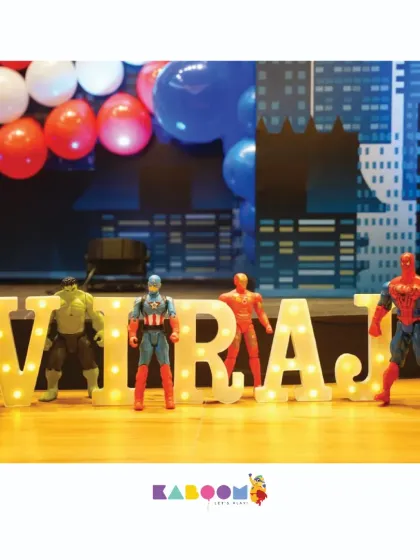 We personalize your superhero party with details like these light-up marquee letters spelling out the birthday child's name, guarded by their favorite Avengers action figures.