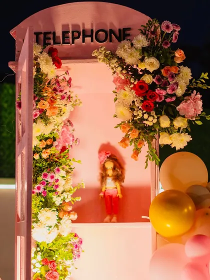 A beautiful telephone booth prop filled with flowers, a romantic and whimsical detail.