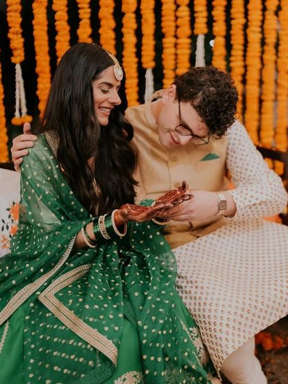 A duplicate of 300, this image focuses on the couple's interaction over the beautiful henna design.