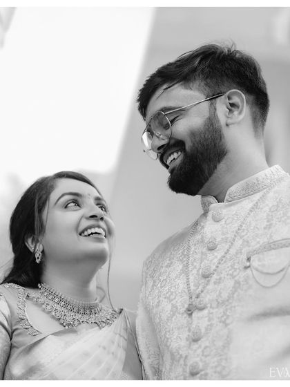 A beautiful black and white photo capturing the shared laughter and joy between Amruta and Varun.