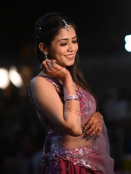 A stunning look for a wedding guest. The makeup is soft and shimmery, with a focus on the eyes, and her smile shows she's ready to celebrate.
