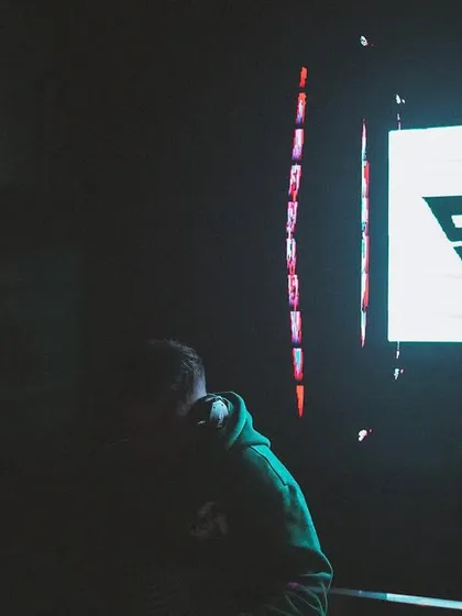 A darker, more mysterious shot where I'm a silhouette against my own logo. It shows that the brand is as much a part of the show as I am.