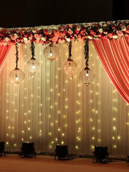 A closer view of the fairy light stage, with hanging glass lanterns adding a touch of rustic charm to the romantic setup.
