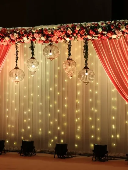 A closer view of the fairy light stage, with hanging glass lanterns adding a touch of rustic charm to the romantic setup.