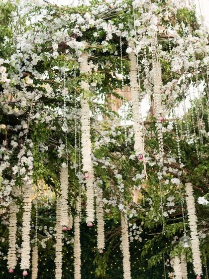 A close-up of the thousands of delicate white floral strings used to create a curtain-like effect. This detail adds incredible texture and a sense of ethereal beauty to the ceremony decor.