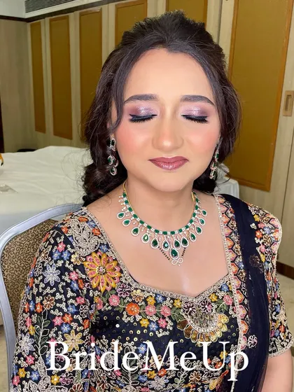Amita with her eyes closed, showcasing the beautiful purple and silver eyeshadow blend for her reception look.