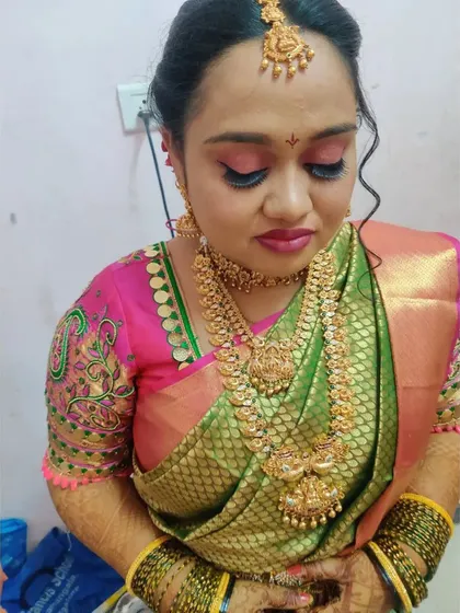 This bride's look for her muhurtham features a beautiful combination of pink and green. I used a soft pink eyeshadow and a matching lip color to complement her silk saree and intricate temple jewellery.