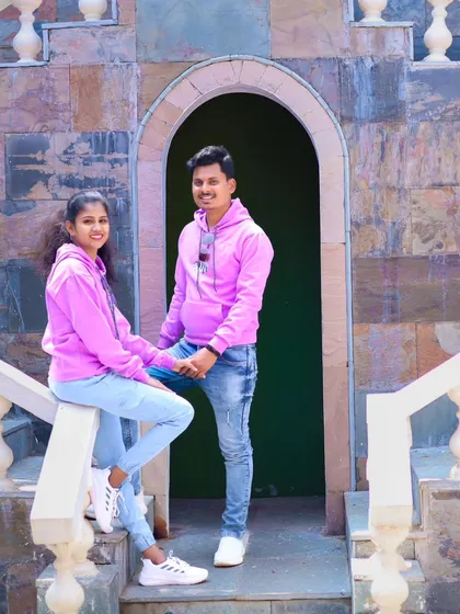 A cool and casual pose on a staircase. The couple's matching pink hoodies add a fun, coordinated touch.