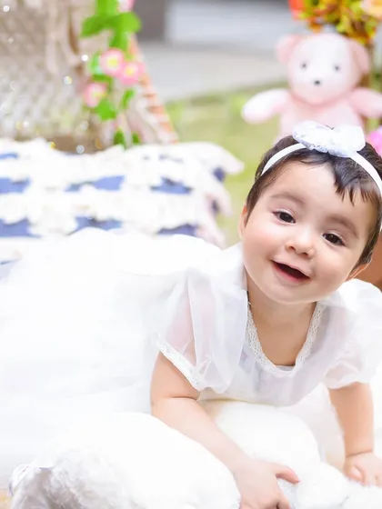 A happy crawl towards the camera. This candid shot perfectly captures the playful energy of a one-year-old exploring her birthday setup.