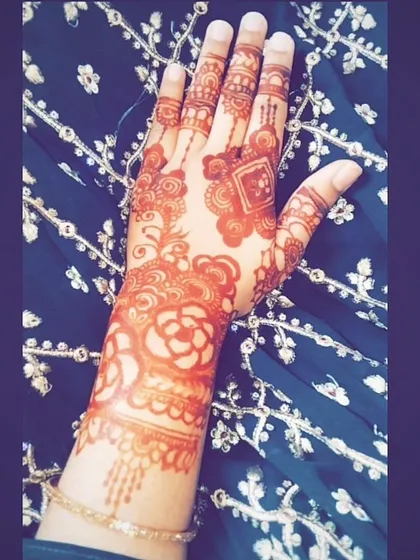 A beautiful, dark stain on a floral and geometric design. The contrast with the client's embroidered outfit is just stunning.