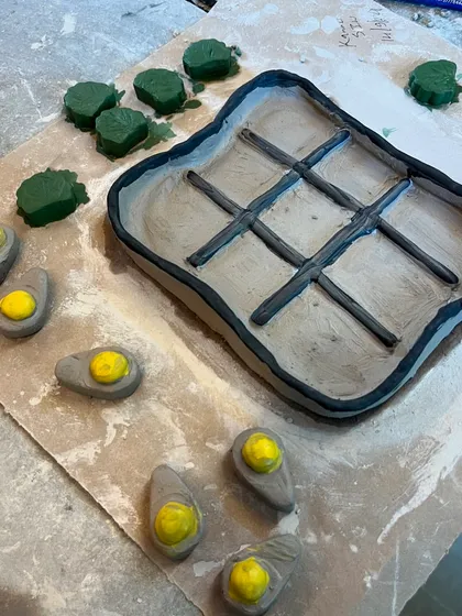 A work-in-progress shot of a unique tic-tac-toe set from our workshop. This one features a grilled steak board with deviled eggs as the game pieces, showing how creative our participants get.
